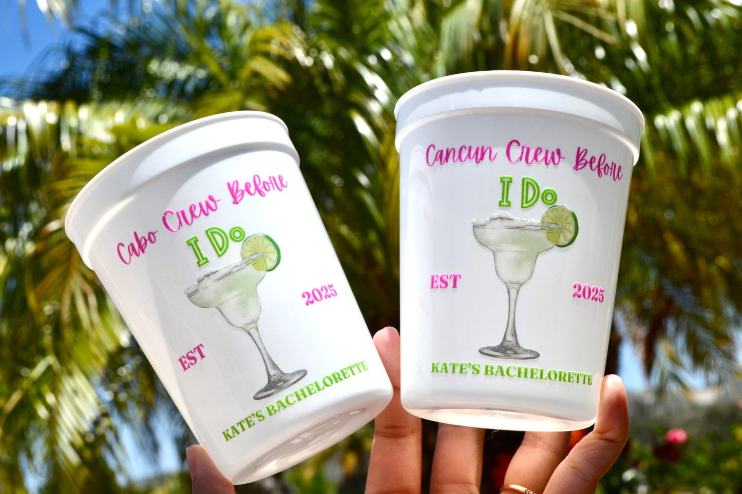 Two cups with personalized designs and text against a blurred natural background