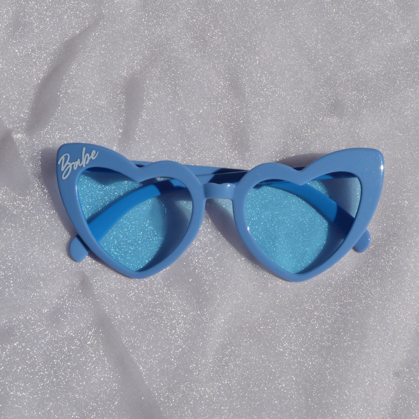 Blue sunglasses with gradient lenses on a textured gray surface