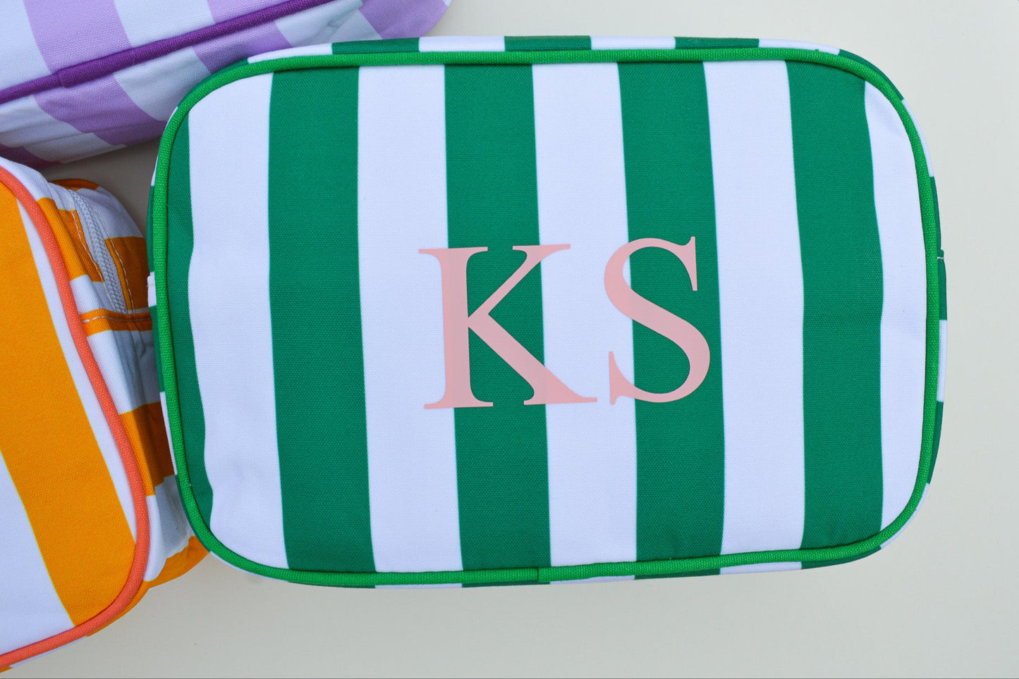 Green and white striped pouch with 'KS' monogram on a light background