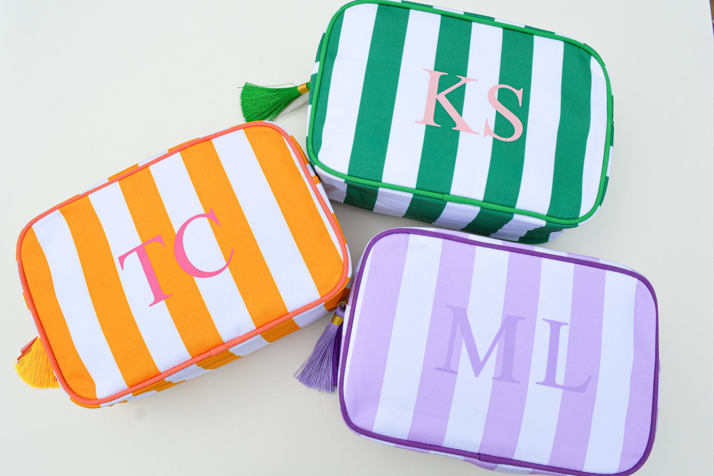Three striped pouches with monograms on a light background