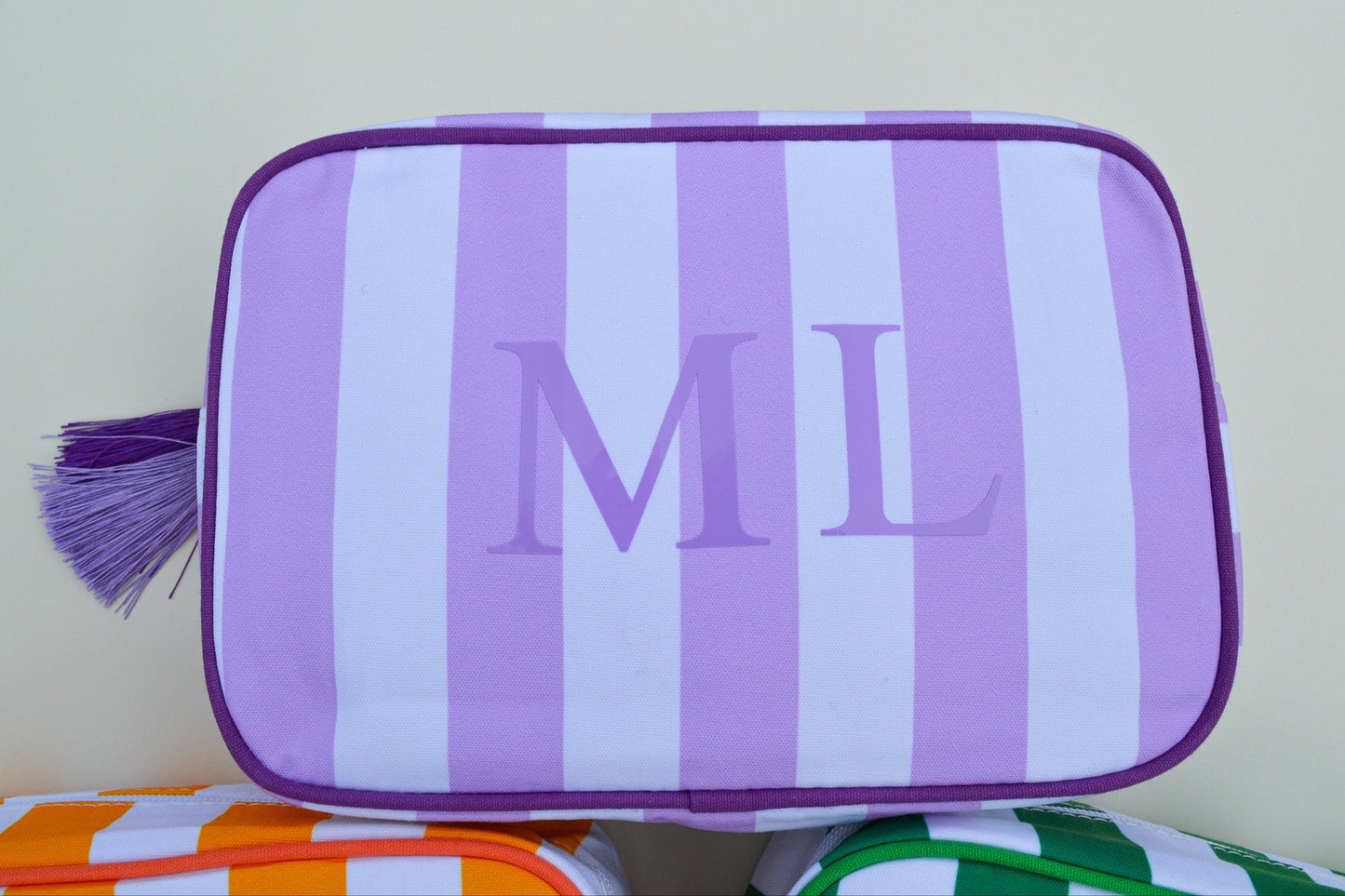 Purple and white striped pouch with 'ML' initials on a light background
