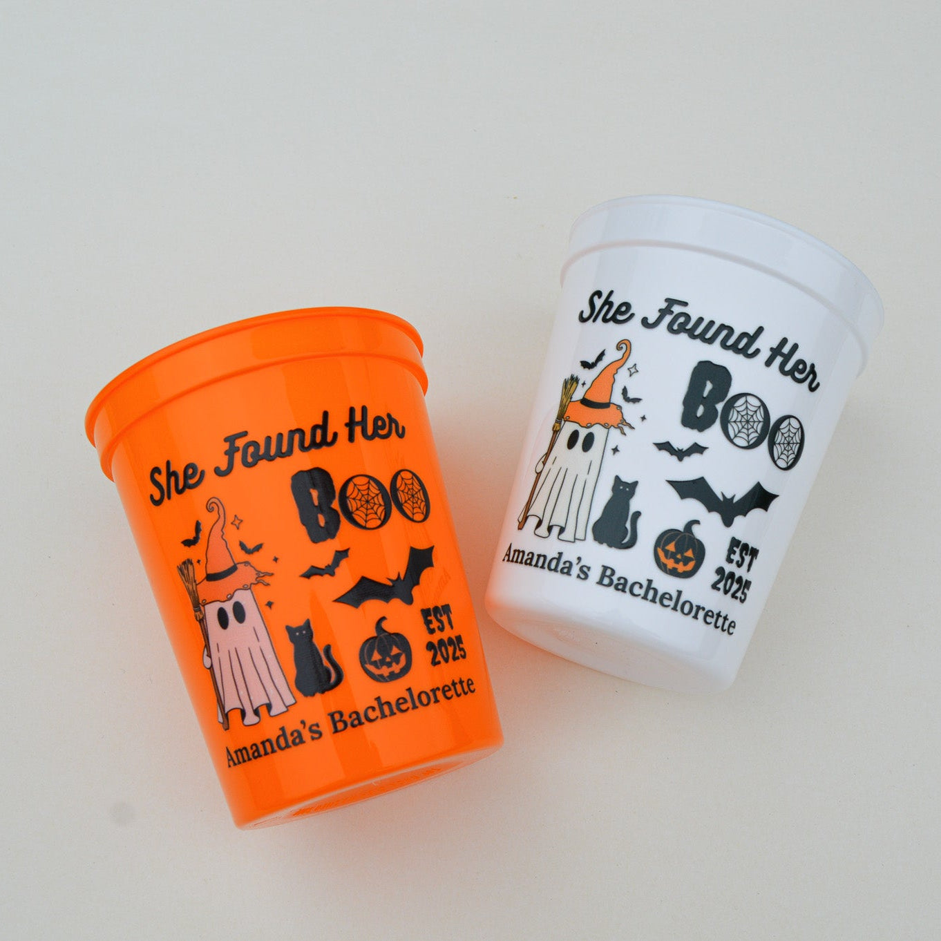 Two Halloween-themed cups with text and graphics on a light background