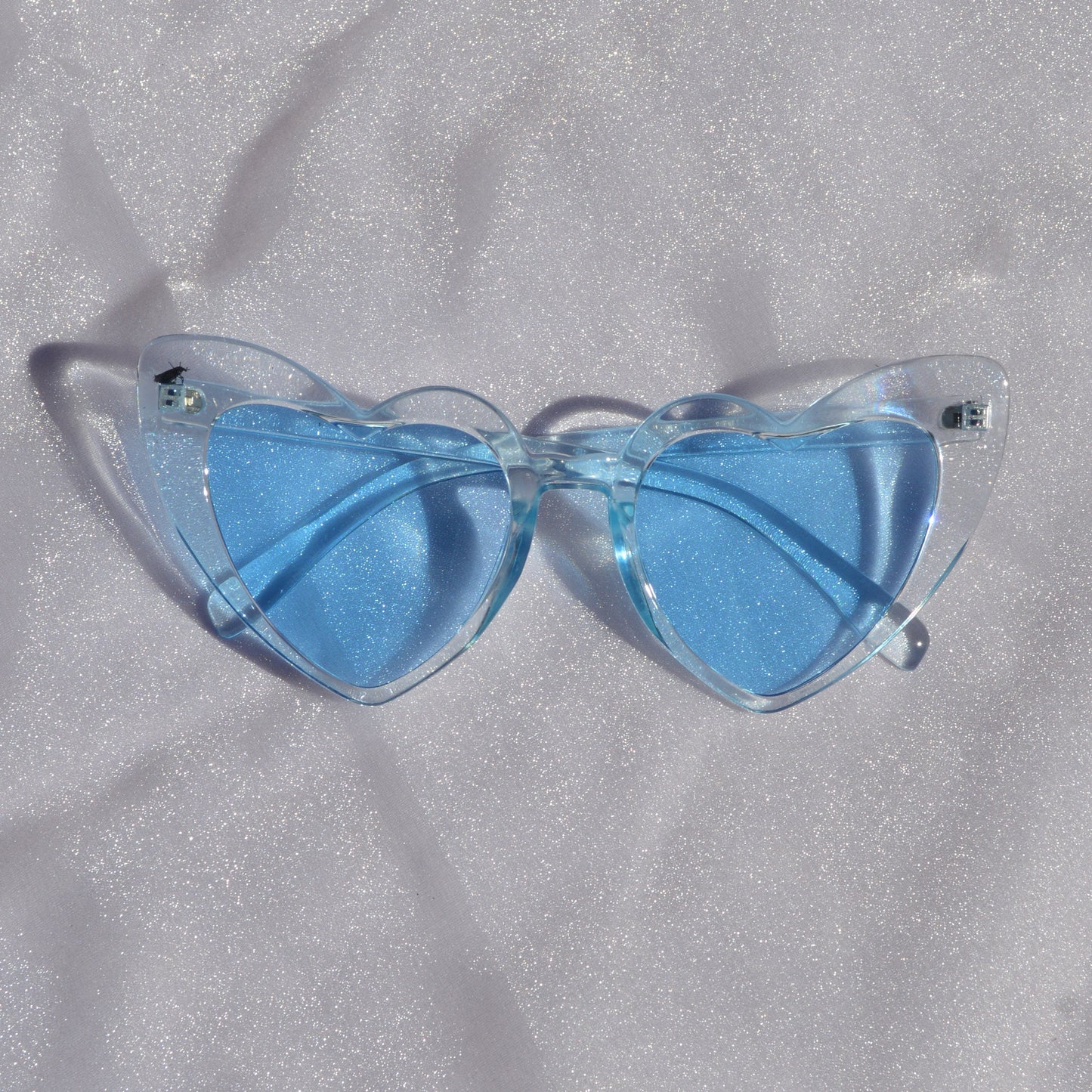 Blue sunglasses on a textured gray surface