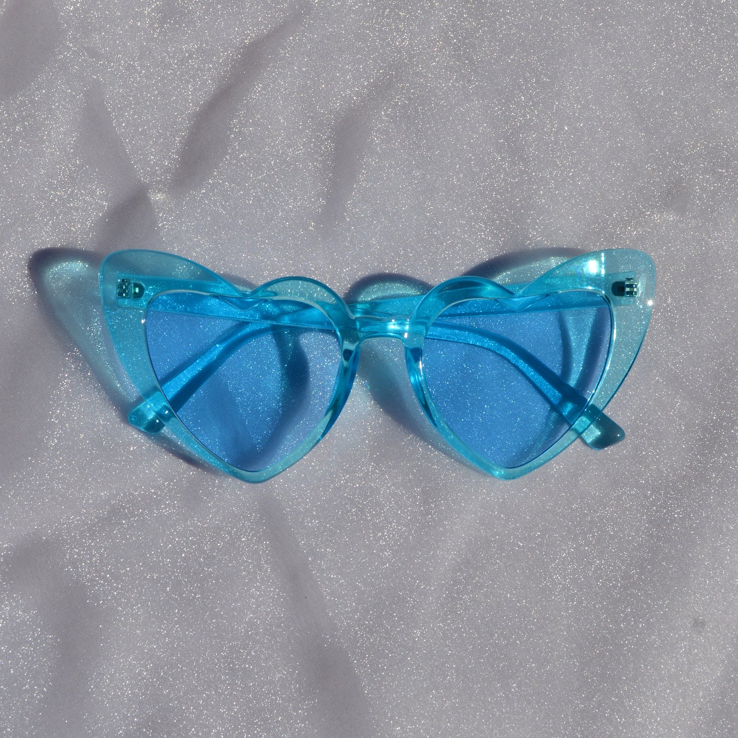 Blue sunglasses on a gray textured surface