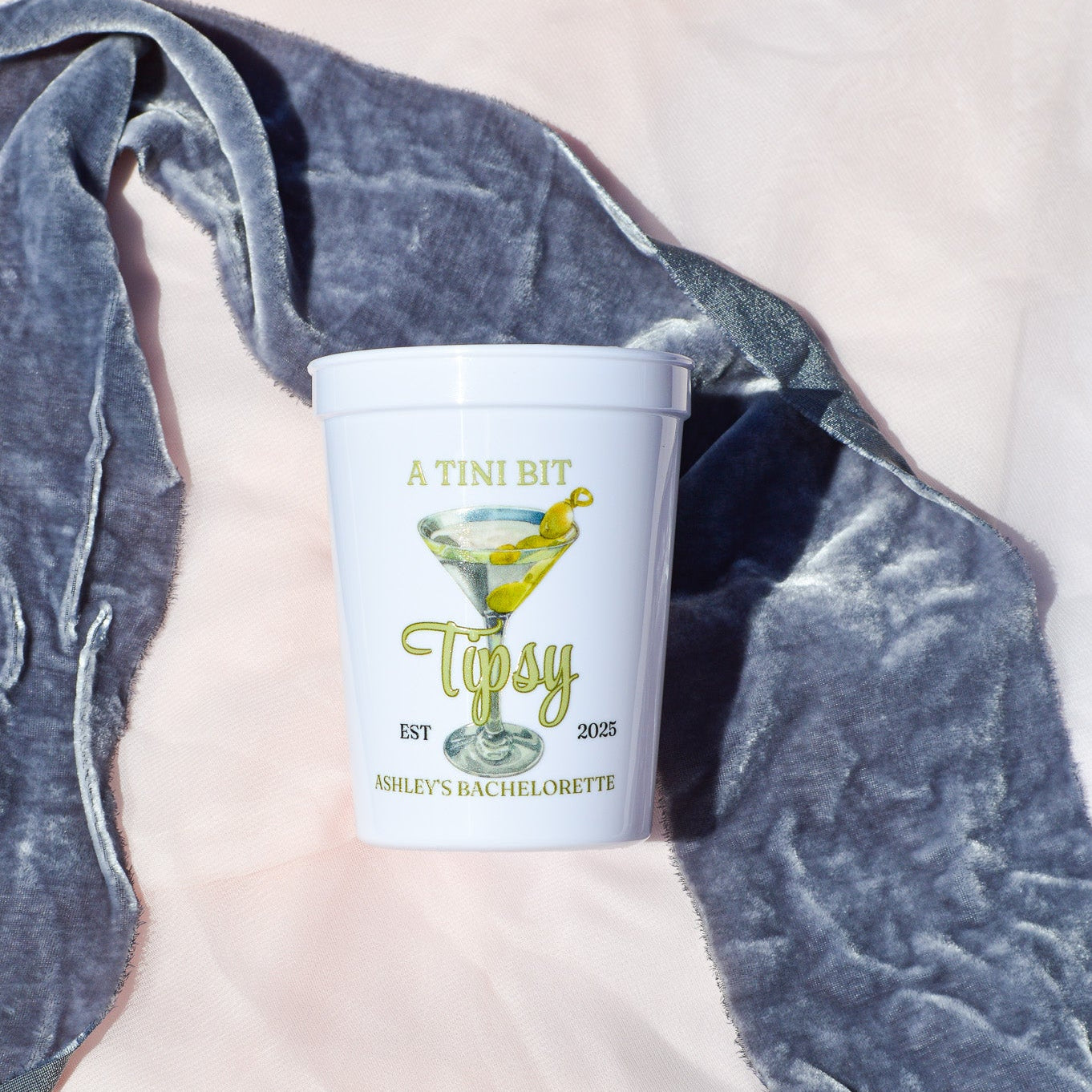 White cup with 'Tipsy' branding on a textured surface