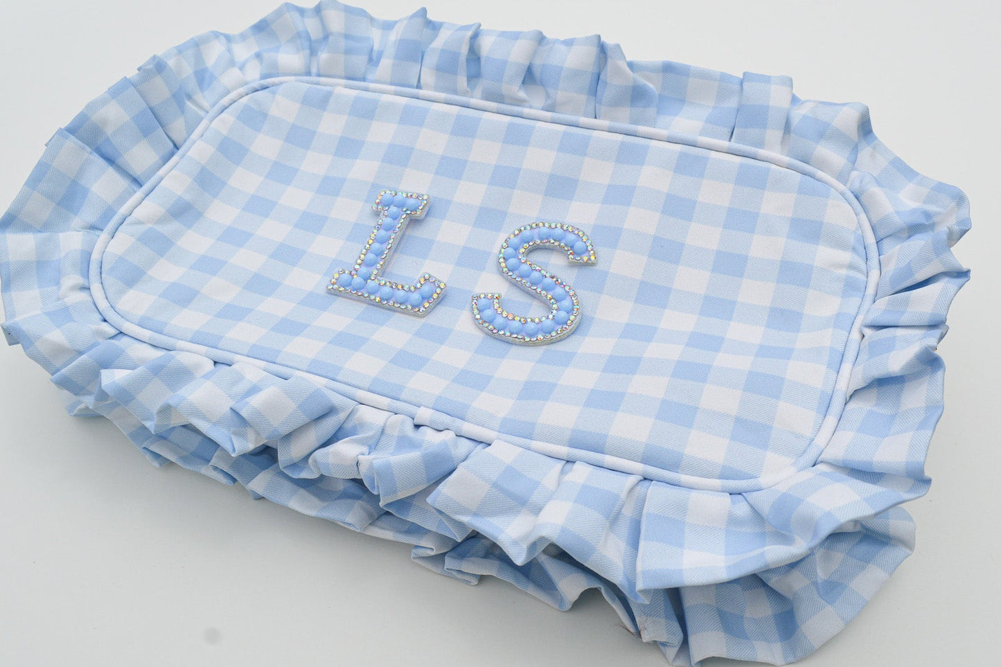 Blue and white checkered pouch with 'LS' initials on a white surface