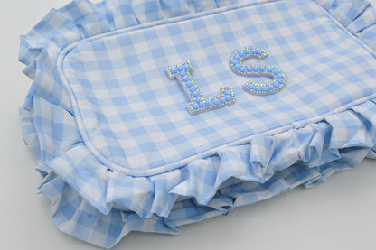 Blue and white checkered bag with ruffles and 'LS' initials on a light gray background