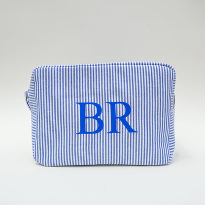 Blue and white striped pouch with 'BR' initials on a light gray background