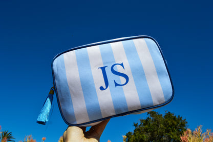 Blue and white striped pouch with 'JS' monogram against a clear blue sky