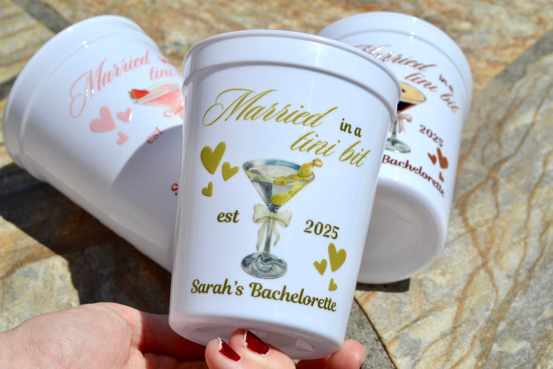 Personalized bachelorette party cups with text and graphics on a stone surface