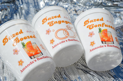 Three cups with personalized text and graphics on a textured surface