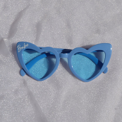 Blue sunglasses with gradient lenses on a textured gray surface