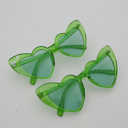 Green sunglasses with transparent frames on a light gray background