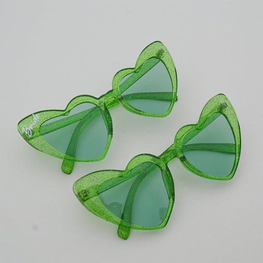 Green sunglasses with transparent frames on a light gray background