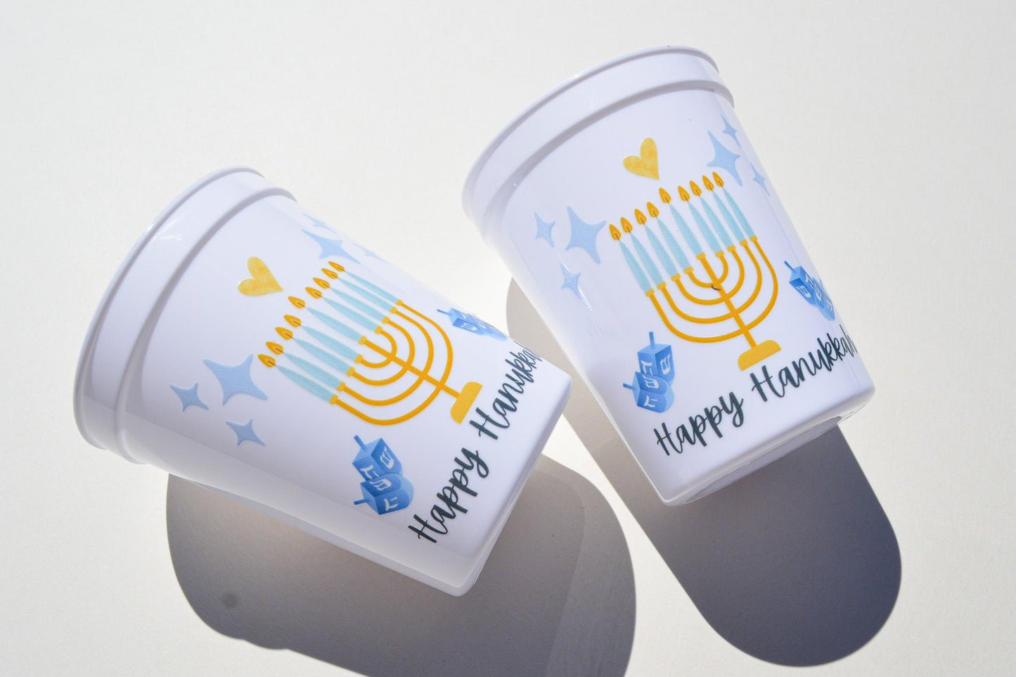 Two plastic cups with Hanukkah-themed designs on a white background