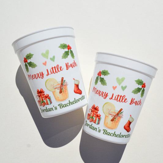 Two white cups on a gray background with festive text that says "Merry Little Bach" 