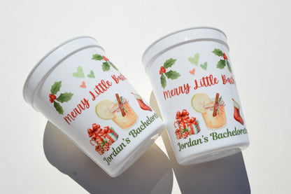 Two festive-themed cups with holiday designs and text on a white background