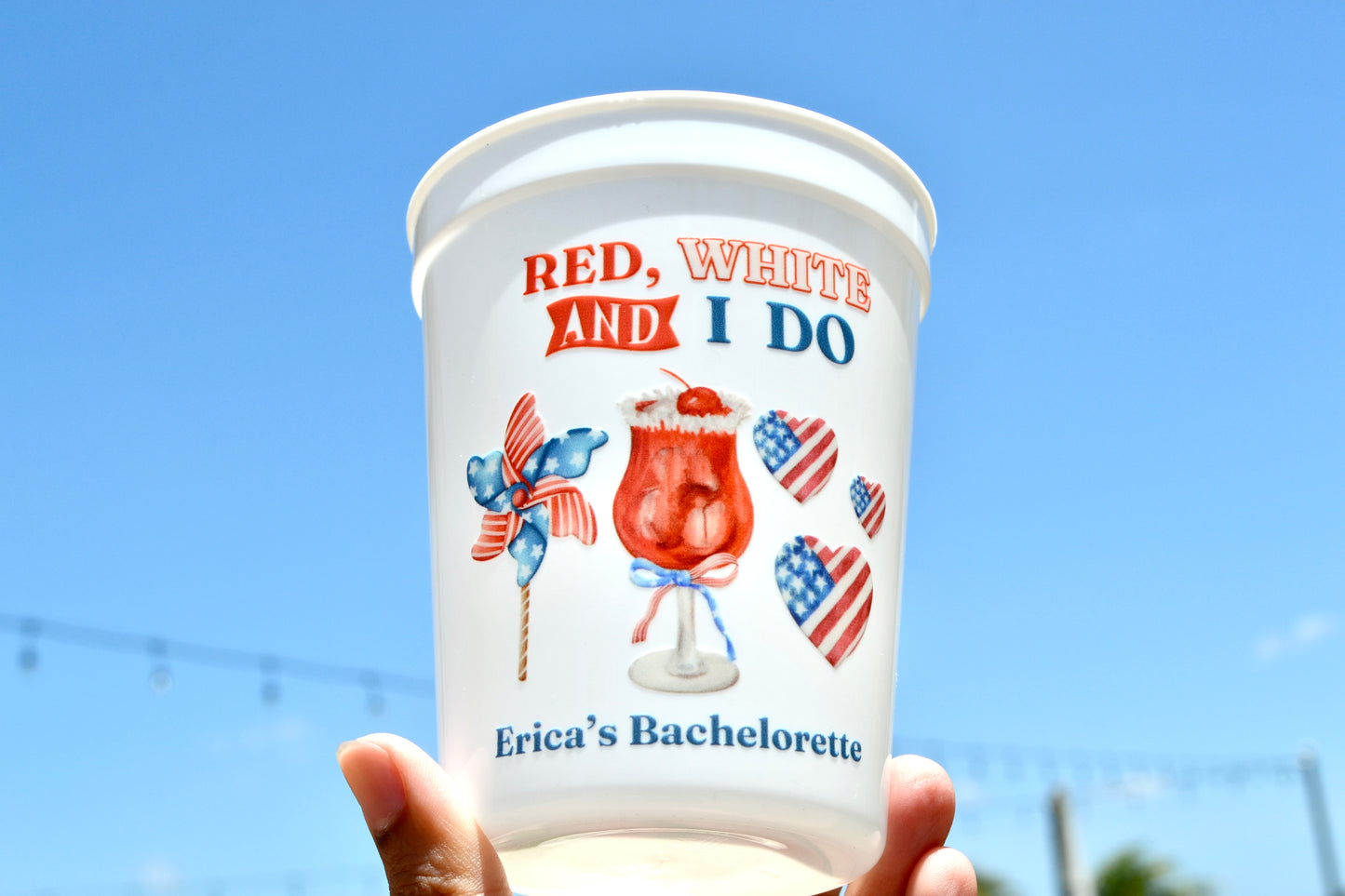 Personalized cup with 'Red, White and I Do' design against a blue sky