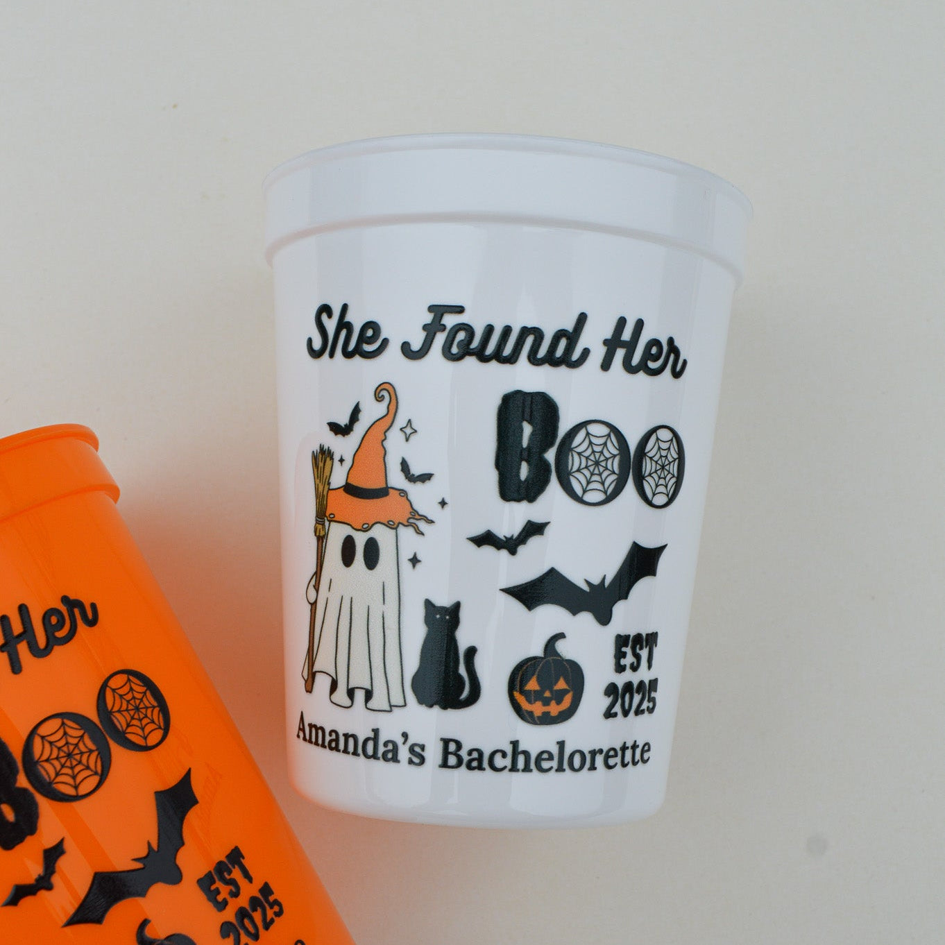 Halloween-themed cup with graphics and text on a plain background