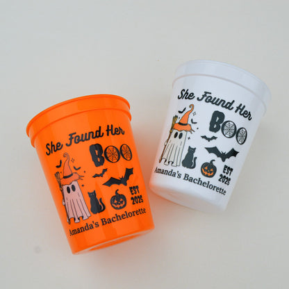 Two Halloween-themed cups with text and graphics on a light background
