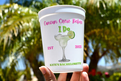 Personalized bachelorette party cup with margarita design and text, held in front of palm trees.