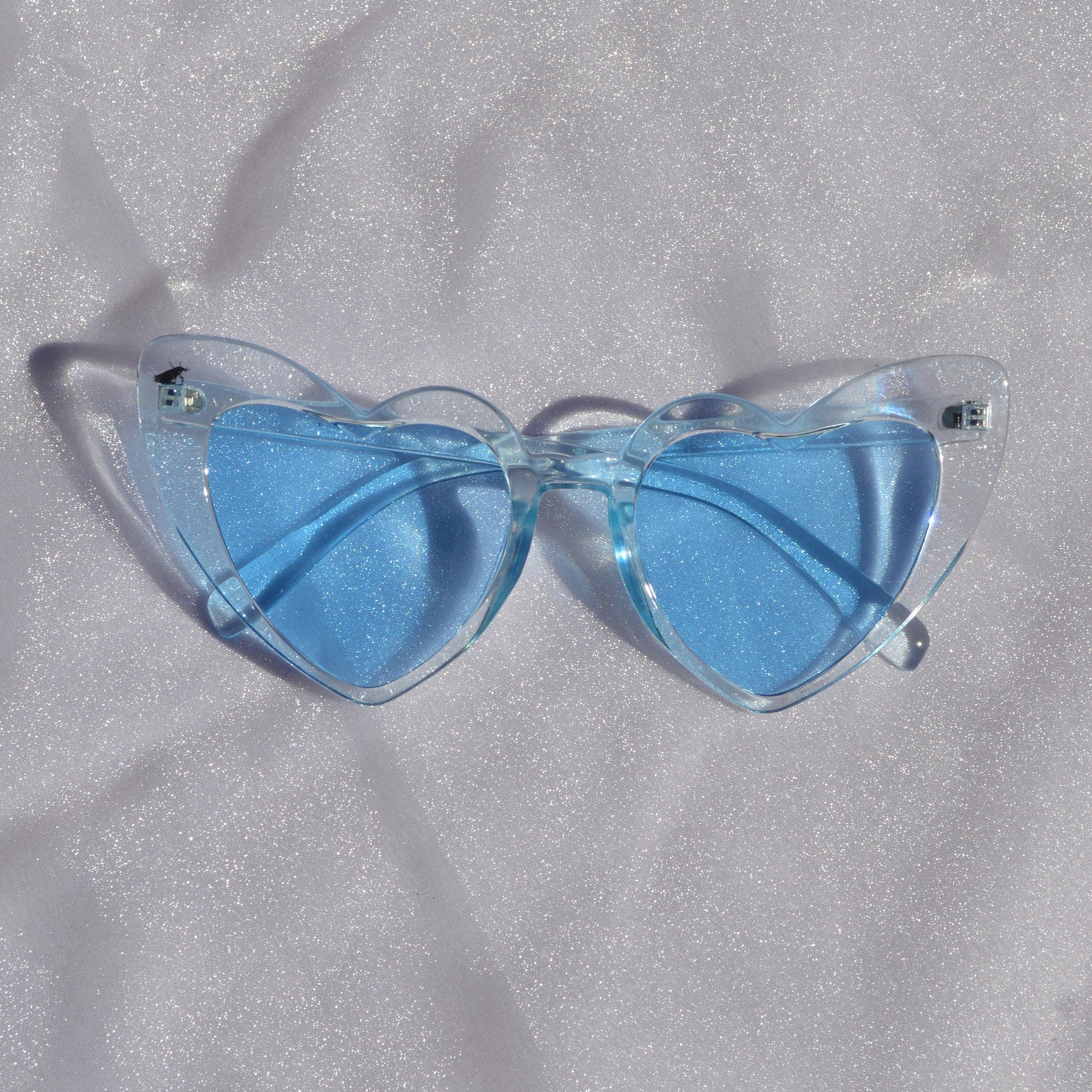 Blue sunglasses on a textured gray surface