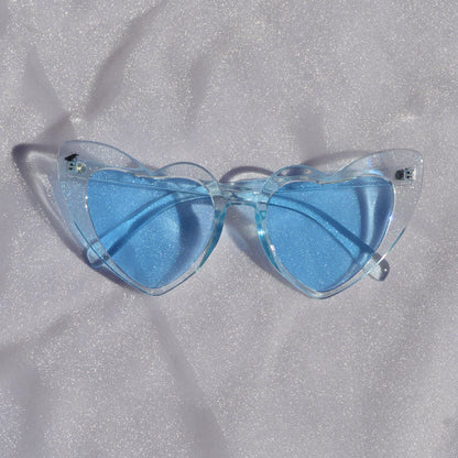 Blue sunglasses on a textured gray surface