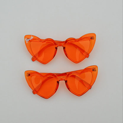 Pair of orange cat-eye sunglasses on a light gray background