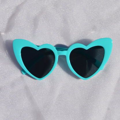 Turquoise sunglasses on a white fabric background