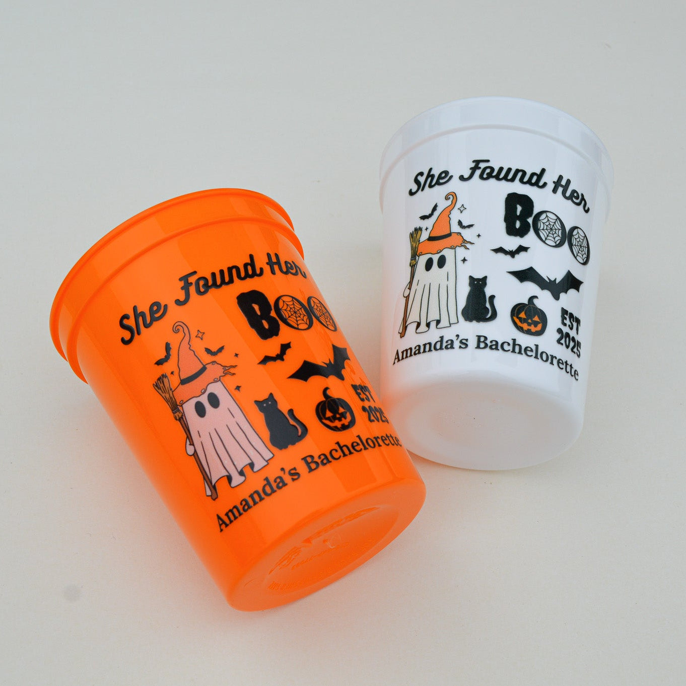 Two Halloween-themed cups on a white surface