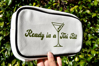 White pouch with 'Ready in a Jui Bit' text and martini glass design held against a green leafy background.